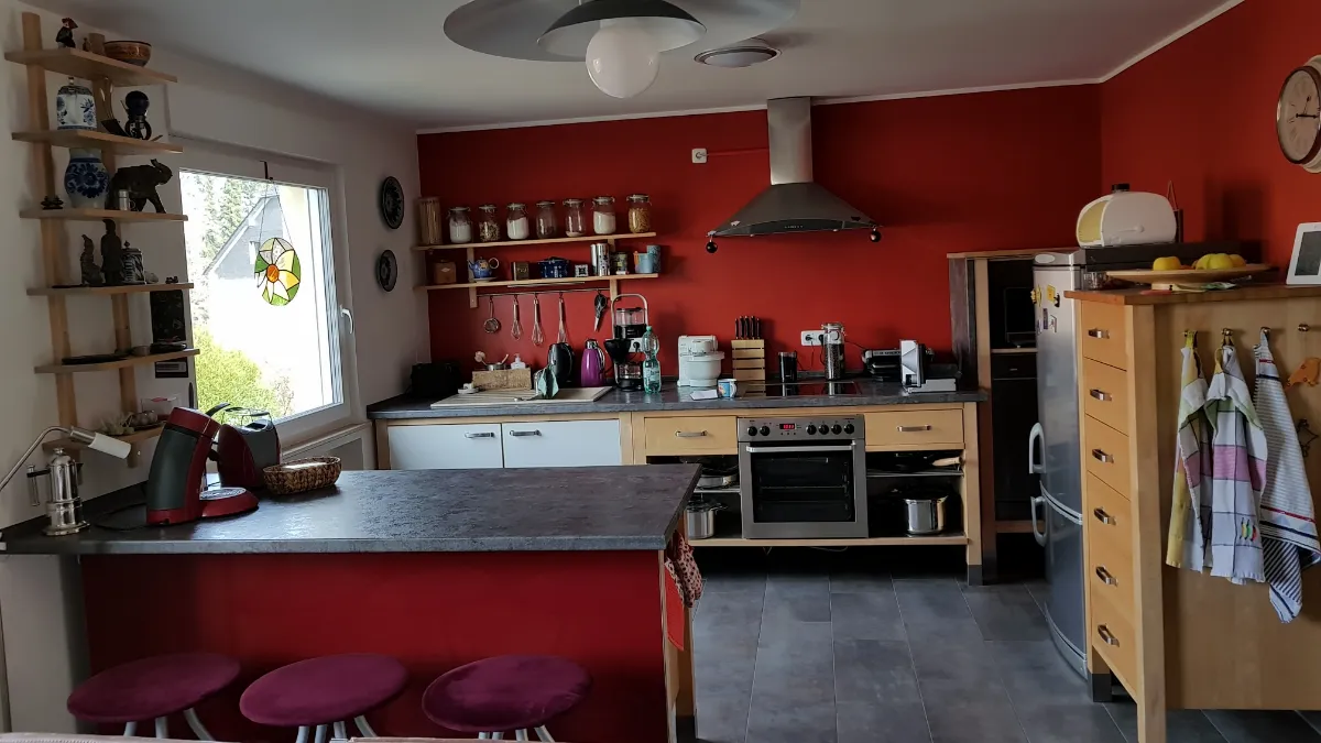 Renovierte Küche mit roter Wand und neuem Fenster