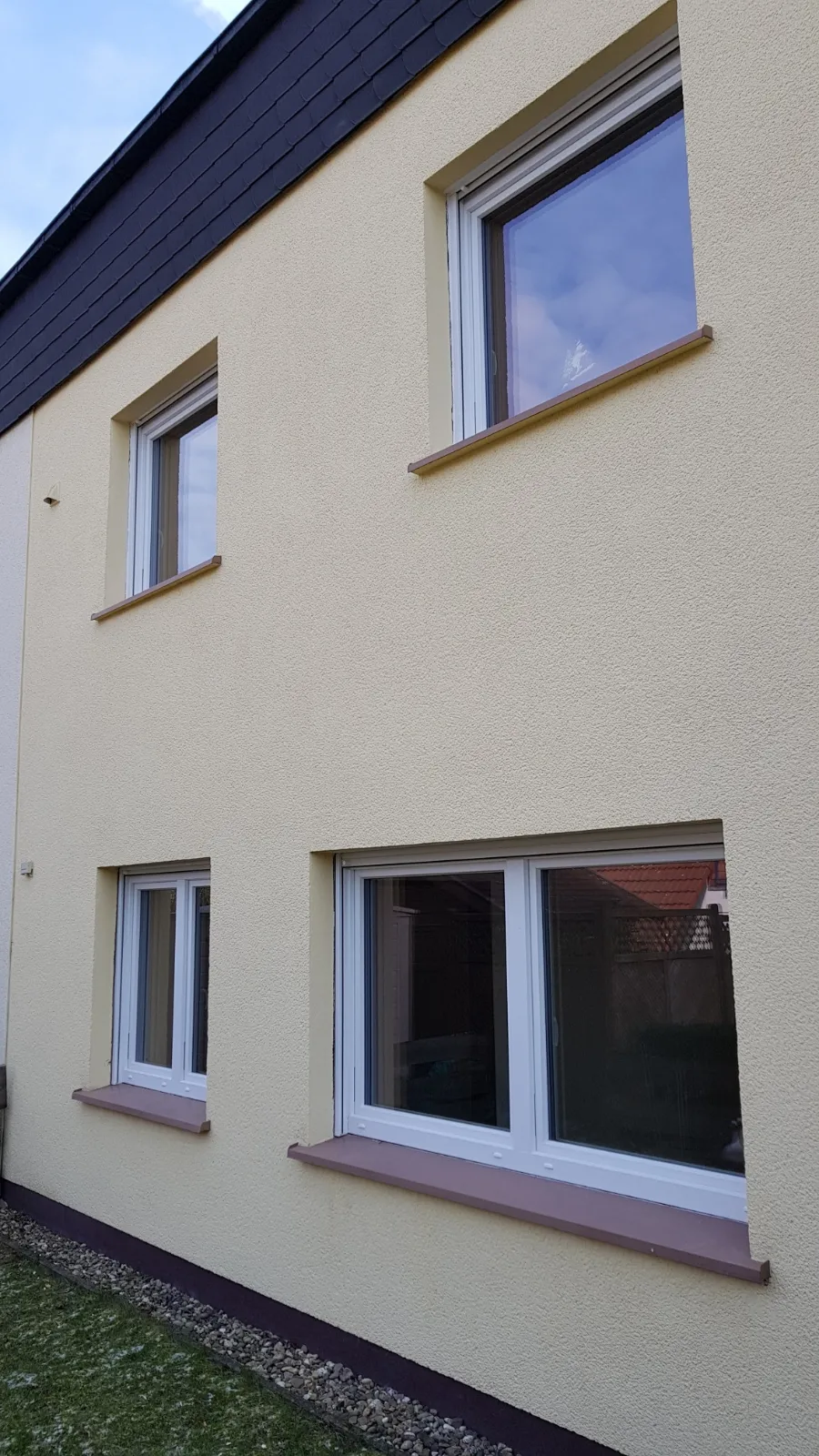 Hausfassade mit neuen weißen Fenstern